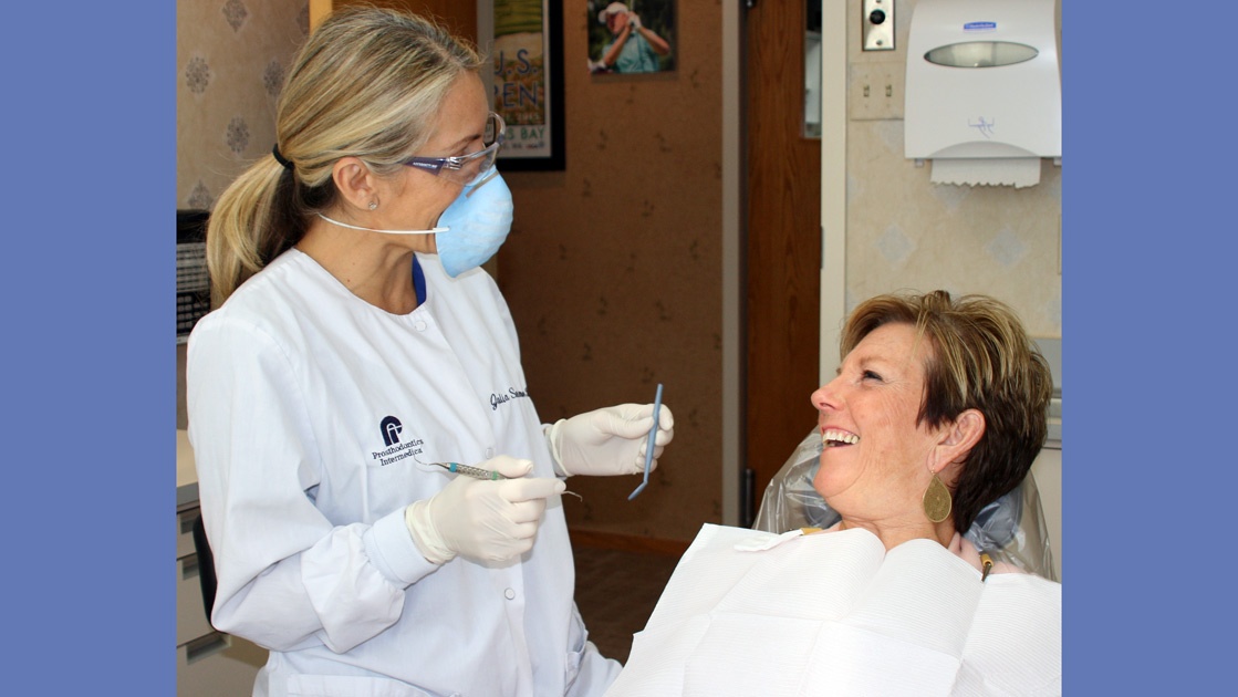Veteran Dental Hygienist, Julia, chats with patient during oral hygiene appointment